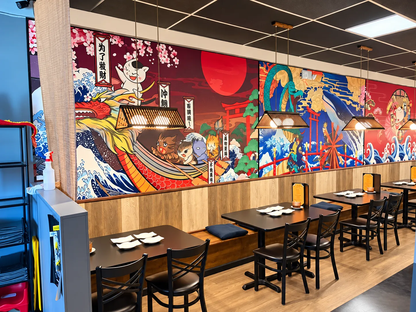 Dining room at Tougen with a wall-length Japanese mural above the tables