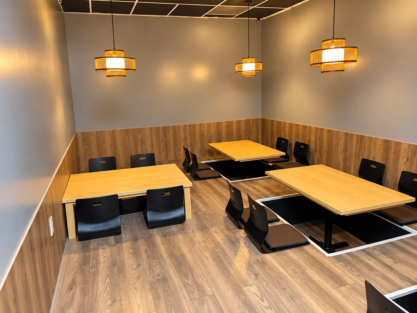 Sunken tables with floor chairs and bamboo lanterns at Tougen